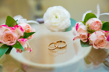 Wedding boutonniere and wedding rings on glass