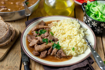 Pork fricassee stew in tomato sauce with semolina