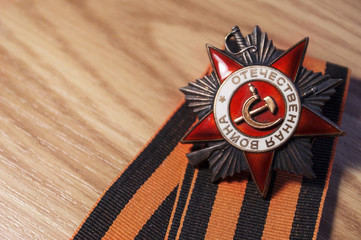 Order of the Patriotic War in St. George's Ribbon on a wood background.