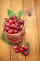 Fototapeta na wymiar Freshly picked cherries in Cute Basket on a wooden Table