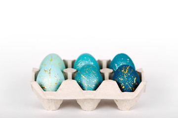 Stylish  blue easter eggs in paper tray with copy space on white background. Easter concept
