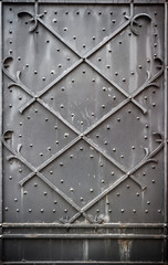 Background - part of steel door reinforced with steel belts and rivets