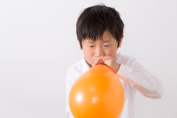 風船を膨らます子供
