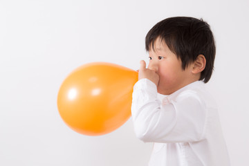 風船を膨らます子供