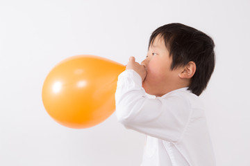 風船を膨らます子供