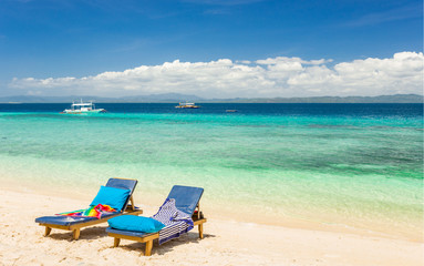 Beach chairs, clear water and beautiful view on tropical island,