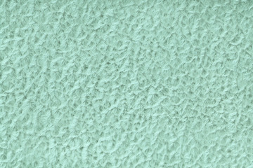 Light green fluffy background of soft, fleecy cloth. Texture of textile closeup