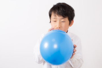 風船を膨らます少年