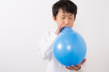 風船を膨らます少年
