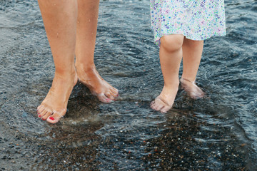 Mother and daughter walking along the seashore