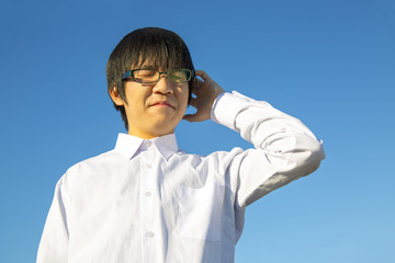 ワイシャツ姿で悩む男子高校生゜