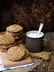 Flourless gluten free peanut butter, oatmeal, dried fruits cookies and cup of cocoa with marshmallows on wooden background. Vertical. Copy space