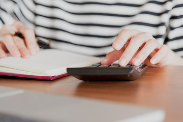 Fototapeta premium Business women work with calculator and laptop,pen and notebook on the wooden table