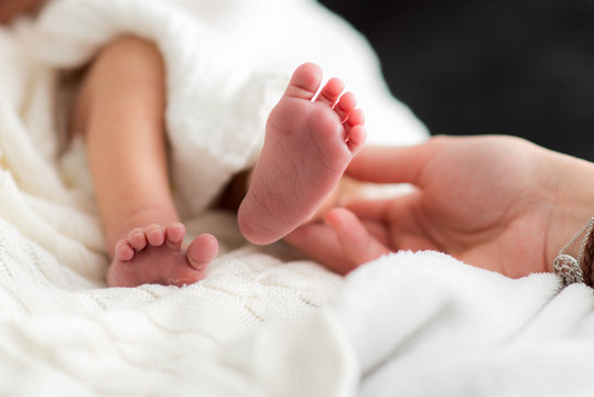 Zerbrechliche Füße neugeborenes Baby Säugling in Kinderstube