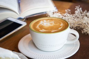 coffee cup and tasty cake relax time book and mobile phone on table in coffee shop