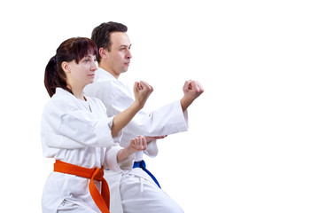 Man and woman in karategi stand in the rack karate