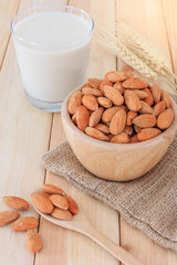 Almond milk in glass with almonds on wooden table, Close up
