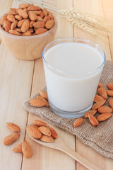 Almond milk in glass with almonds on wooden table, Close up
