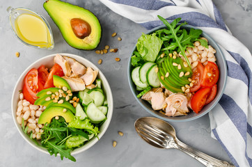 Salmon with white bean, tomatoes, cucumbers, avocado and arugula salad