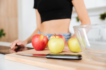 Cropped image of woman with apples on table