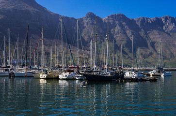 Sailing boats and yachts in marina at sunset.