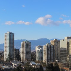 Fototapeta na wymiar City landscape with high rises and mountains