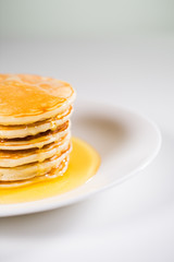 Stack of Small pancakes in syrup