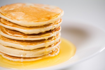 Stack of Small pancakes in syrup