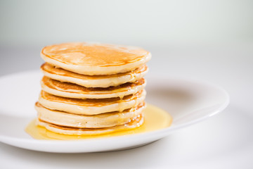 Stack of Small pancakes in syrup