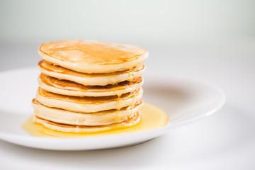 Stack of Small pancakes in syrup