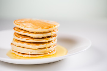 Stack of Small pancakes in syrup