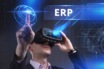 Business, Technology, Internet and network concept. Young businessman working in virtual reality glasses sees the inscription: ERP