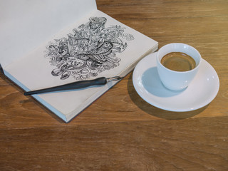 Drawing Doodle line art by black ink on paper with a cup of coffee