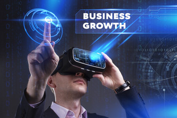 Business, Technology, Internet and network concept. Young businessman working in virtual reality glasses sees the inscription: Business growth
