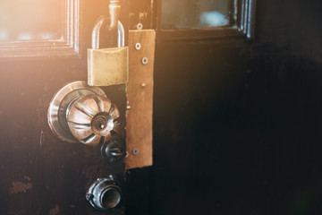 Vintage tone of security lock - door knob - padlock on the old wooden door