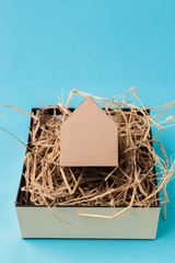 house model cardboard in a box with hay and free copyspace house concept