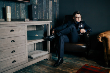 Male businessman in a jacket and suit, dark background.