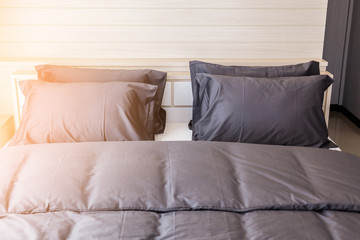 Bed maid-up with clean white pillows and bed sheets in beauty room. Close-up. Lens flair in...