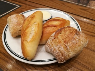 Assortment of different types of French bread as side dish serve with salted butter on table, focus-on-foreground bread with blur bread and table background