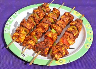 Paneer tandoori tikka masala; classic and traditional Indian dish; on the blue background in white plate.
