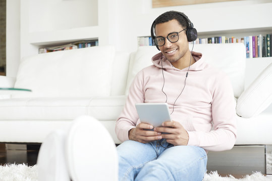 Enjoy music. Young African American man listening music on digital tablet