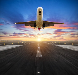 Airplane landing to airport runway in sunset light