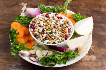 Mix of vegetable ingredients for vegetarian soup on wooden background