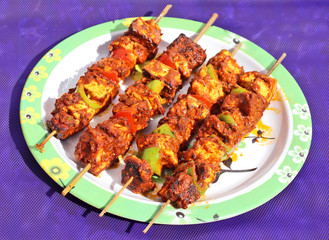 Paneer tandoori tikka masala; classic and traditional Indian dish; on the blue background in white plate.