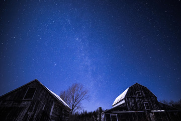 Rural barns at night with stars in winter