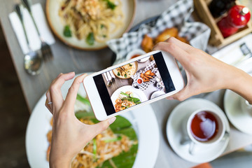 Woman taking photo on cellphone on dish