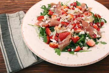 Arugula salad with strawberries, feta cheese, prosciutto, parmes