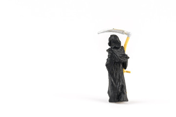 Miniature grim reaper on background with space for text