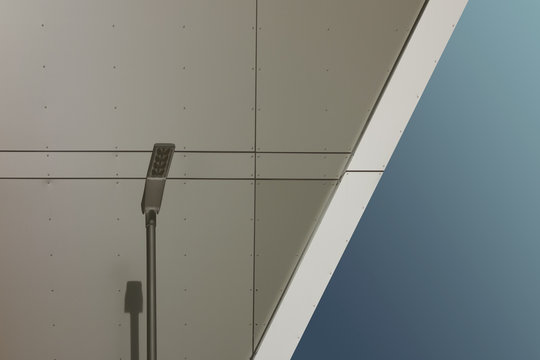 Laterne mit Schatten vor moderner Fassade