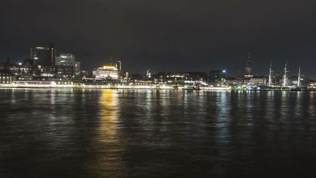 Panomic time lapse from the opposite riverside of the Elbe in Hamburg, on the skyline of hamburg, st. Pauli, Landungsbruecken, Baumwall, in evening time. Night Scene. 4k